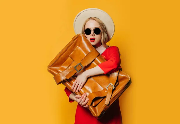 Sarı Arka Planda Bavulu Olan Kırmızı Elbiseli Sarışın Kadın Şaşırdı — Stok fotoğraf