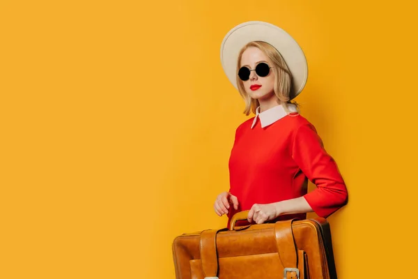 穿着红色衣服 头戴黄色背景手提箱的时髦金发女人 — 图库照片