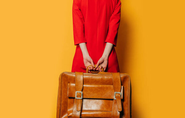 Вид сзади на женщину в красном платье с биноклем на желтом фоне