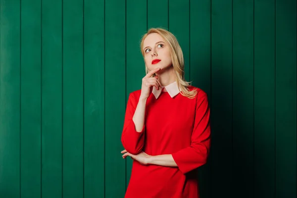 Zaskoczona Blondynka Włosy Kobieta Czerwony Strój Zielonym Drewnianym Tle — Zdjęcie stockowe