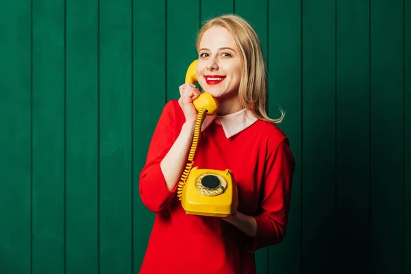Yeşil Ahşap Arka Planda Çevirmeli Telefonu Olan Kırmızı Elbiseli Şık — Stok fotoğraf