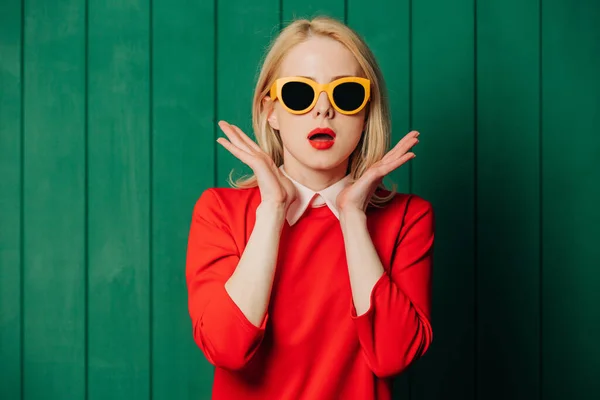 Mujer Elegante Sorprendida Gafas Sol Vestido Rojo Sobre Fondo Madera —  Fotos de Stock