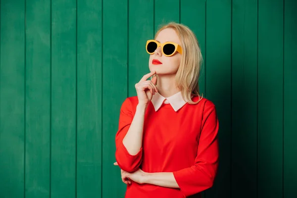 Mulher Elegante Surpreendido Óculos Sol Vestido Vermelho Fundo Madeira Verde — Fotografia de Stock
