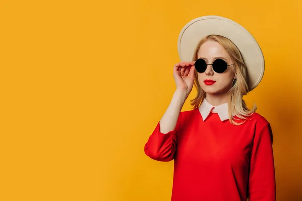 Sarı Arka Planda Kırmızı Elbiseli Güneş Gözlüklü Şık Sarışın Kadın Telifsiz Stok Imajlar