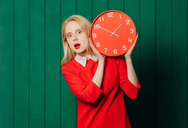 Sorpresa Donna Capelli Biondi Abito Rosso Con Orologio Sfondo Verde Immagine Stock