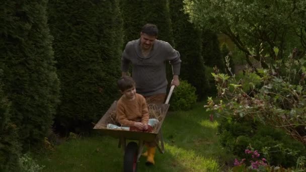 Vader Rijdt Zoon Een Kruiwagen Met Hooi Tuin Het Voorjaar — Stockvideo
