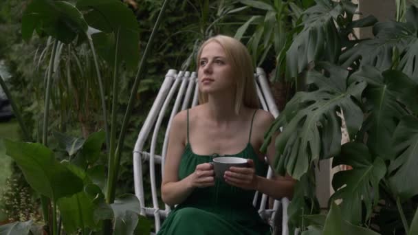 Γυναίκα Πράσινο Φόρεμα Κάθεται Στην Καρέκλα Γύρω Από Φυτά Και — Αρχείο Βίντεο