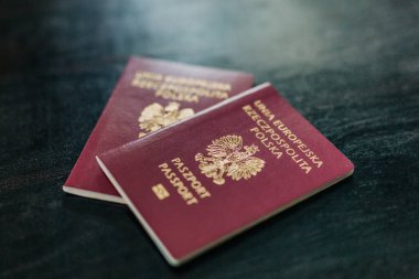 İki Polonya pasaportu bir evde bir masada, göçü ve vatandaşlığı sembolize ediyor.