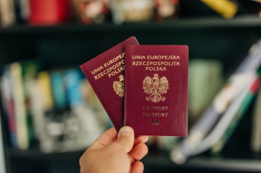Adamın elinde Polonya pasaportu var. Göç ve vatandaşlığı simgeliyor.