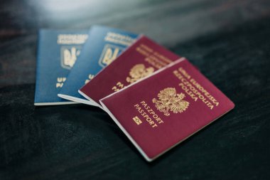 İki pasaport, bir Polonyalı ve bir Ukraynalı, bir evde bir masada, göçü ve vatandaşlığı sembolize ediyor.