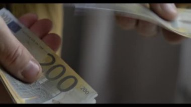Yukarıdan bakıldığında, elinde avro banknotları sayan bir kadının videosu.