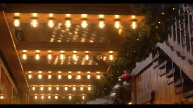 Wroclaw 'daki Noel pazarındaki ahşap evlerdeki dekoratif ışıkların yakın çekim videosu..