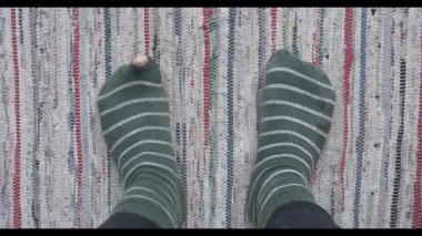 Ayak parmağında delik olan yırtık yeşil çoraplar giyen, evdeki halıda dinlenen, tepeden tırnağa manzaralı bir çift erkek. Krizin ve yoksulluğun kavramsal temsili