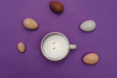 Dekoratif Paskalya yumurtaları ve menekşe arka planda bir fincan kahve..