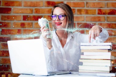 Genç iş kadını kucağında bir dizüstü bilgisayarla oturuyor, elinde bir tuğla duvar zeminine karşı para tutuyor, şifreli para alım satımının dijital bir illüstrasyonuyla