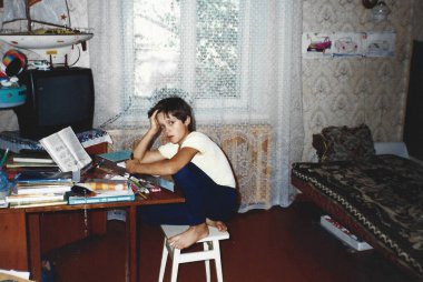 Çocuk ev yapımı taburede oturuyor, 1990 'ların ortalarında Ukrayna' da analog fotoğrafçılık tarzında yakalanmış.
