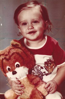 1980 'lerin sonlarında Ukrayna' nın klasik estetik ürünü olan profesyonel ışıklandırma altında oyuncak tutan üç yaşındaki Avrupalı bir çocuğun renkli analog stüdyo portresi.