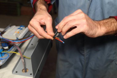 Bir elektrikçi bir cihaz üzerinde çalışır