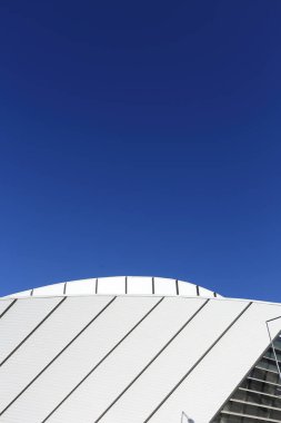 Modern bir şehir binasının ön cephesinin bir parçası mavi gökyüzü arka planına karşı