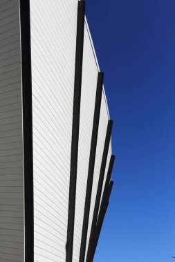 Modern bir şehir binasının ön cephesinin bir parçası mavi gökyüzü arka planına karşı