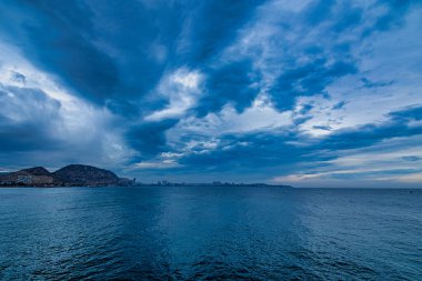 beautiful seaside landscape with clouds and sailboat on the horizon Alicante Spain