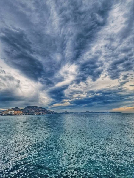 beautiful seaside landscape with clouds and sailboat on the horizon Alicante Spain