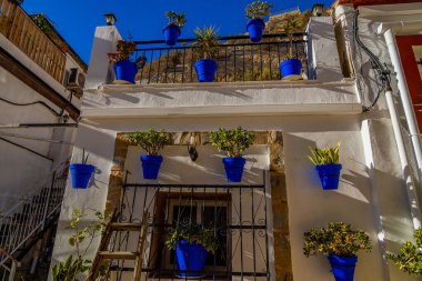 beautiful blue pots with flowers on a white building in the old town of Alicante Spain