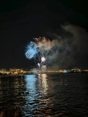 Alicante İspanya 'nın deniz kenarında gece gökyüzünde güzel renkli havai fişekler.