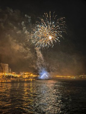 Alicante İspanya 'nın deniz kenarında gece gökyüzünde güzel renkli havai fişekler.