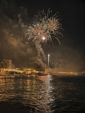 Alicante İspanya 'nın deniz kenarında gece gökyüzünde güzel renkli havai fişekler.