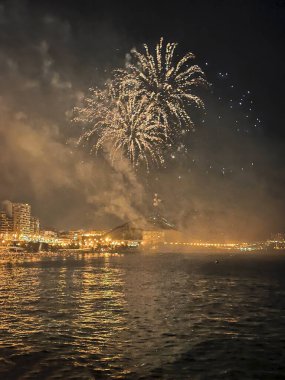 Alicante İspanya 'nın deniz kenarında gece gökyüzünde güzel renkli havai fişekler.