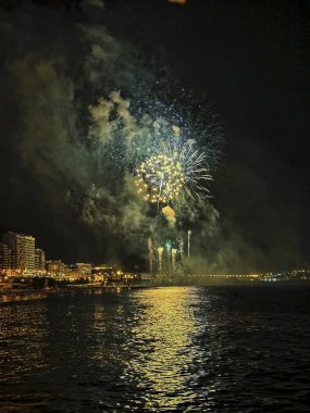 Alicante İspanya 'nın deniz kenarında gece gökyüzünde güzel renkli havai fişekler.