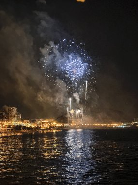 Alicante İspanya 'nın deniz kenarında gece gökyüzünde güzel renkli havai fişekler.