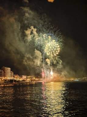 Alicante İspanya 'nın deniz kenarında gece gökyüzünde güzel renkli havai fişekler.