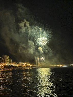 Alicante İspanya 'nın deniz kenarında gece gökyüzünde güzel renkli havai fişekler.
