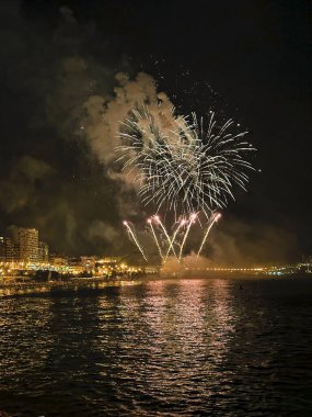 Alicante İspanya 'nın deniz kenarında gece gökyüzünde güzel renkli havai fişekler.
