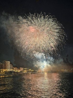 Alicante İspanya 'nın deniz kenarında gece gökyüzünde güzel renkli havai fişekler.