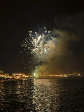 Alicante İspanya 'nın deniz kenarında gece gökyüzünde güzel renkli havai fişekler.