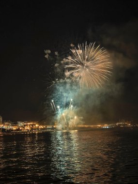 Alicante İspanya 'nın deniz kenarında gece gökyüzünde güzel renkli havai fişekler.