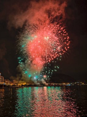 Alicante İspanya 'nın deniz kenarında gece gökyüzünde güzel renkli havai fişekler.