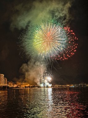 Alicante İspanya 'nın deniz kenarında gece gökyüzünde güzel renkli havai fişekler.