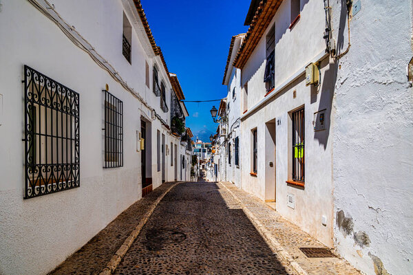 Beautiful urban narrow street in the Spanish city of Altea on a summer day
