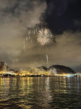 Alicante İspanya 'nın deniz kenarında gece gökyüzünde güzel renkli havai fişekler.