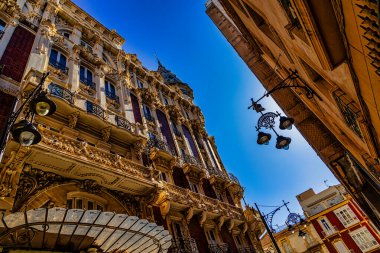 A grand historic building is centered within a lively square Cartagena. clipart