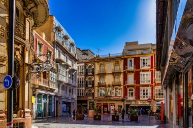 A grand historic building is centered within a lively square Cartagena. clipart