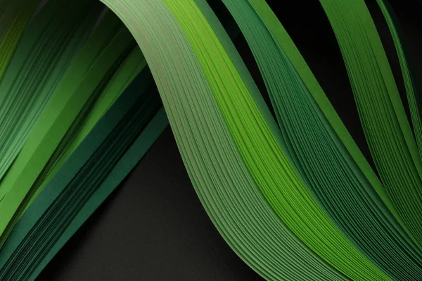stock image Green neon color strip wave paper on black. Abstract texture copy space background.