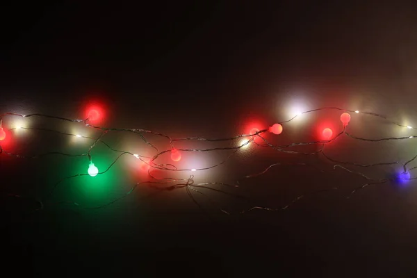 Yumuşak Odak Bulanıklığı Koyu Duvar Arka Planında Noel Çelengi Işıkları — Stok fotoğraf