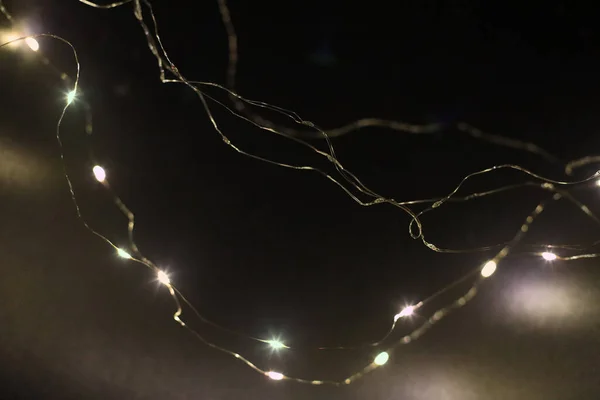 Karanlık Duvar Soyut Arka Planında Hafif Bulanık Noel Çelengi Işıkları — Stok fotoğraf