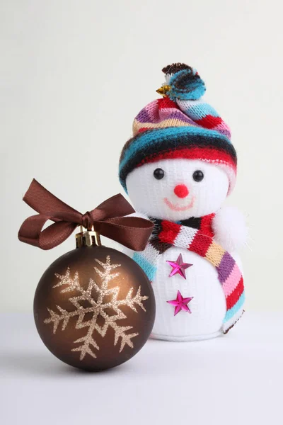 小さなおもちゃの雪だるまと茶色のクリスマスボールを編む — ストック写真