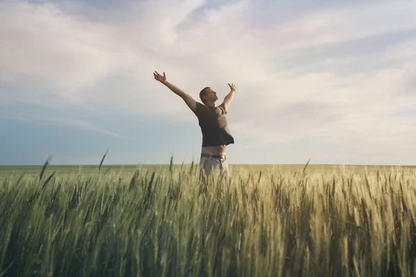 幸せな男は麦畑と空の柔らかい風景に手を上げる 淡い繊細なパステルカラーのトーン コピースペース付きの自然水平背景 — ストック写真